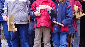 Vier Kinder mit Ratscheninstrumenten