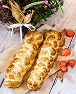 Zwei Allerheiligenstriezel auf einem Brett mit Dekoration